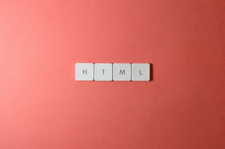Minimalist design of HTML letter tiles on a salmon pink surface.