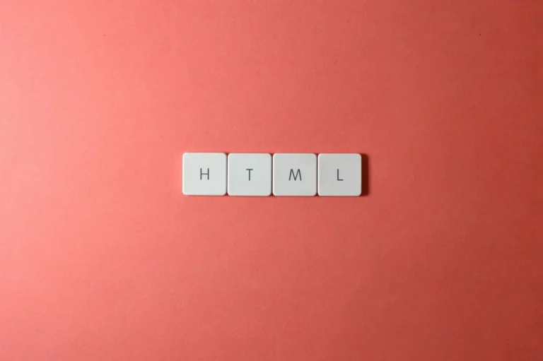 Minimalist design of HTML letter tiles on a salmon pink surface.